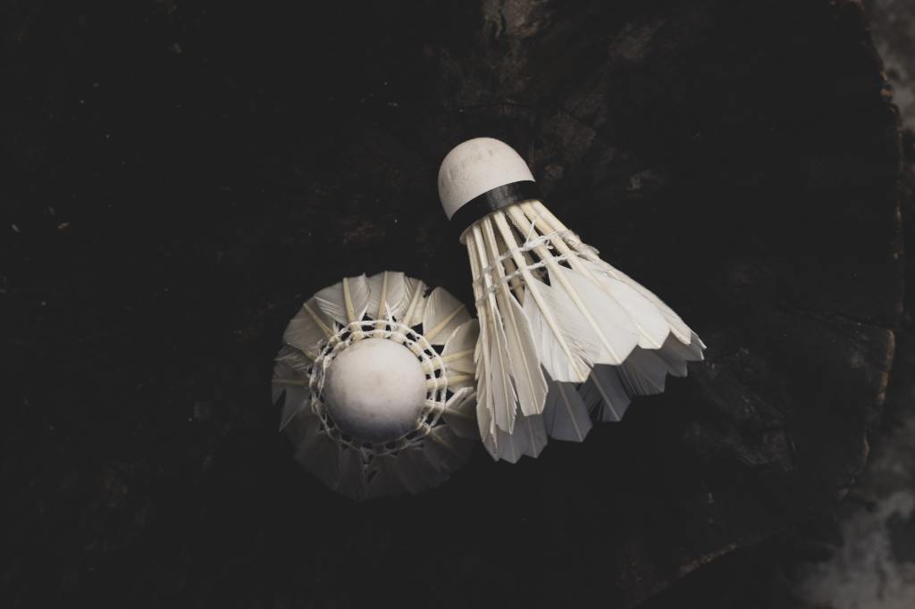 Badminton shuttlecock on a wooden background with a moody environment